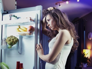 夜中に冷蔵庫を見ている女性