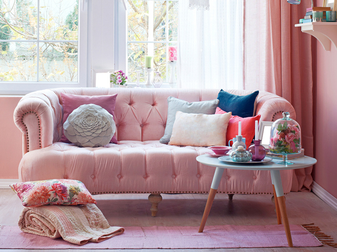 日当たりの良い窓際にピンクのソファにジュータンなどインテリアが素敵