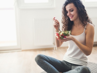 野菜サラダを食べている女性の画像