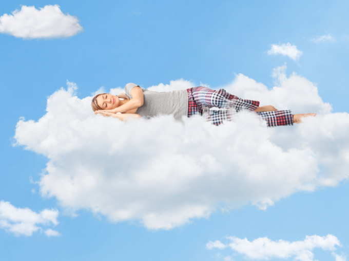 雲の上で眠っている女性の画像
