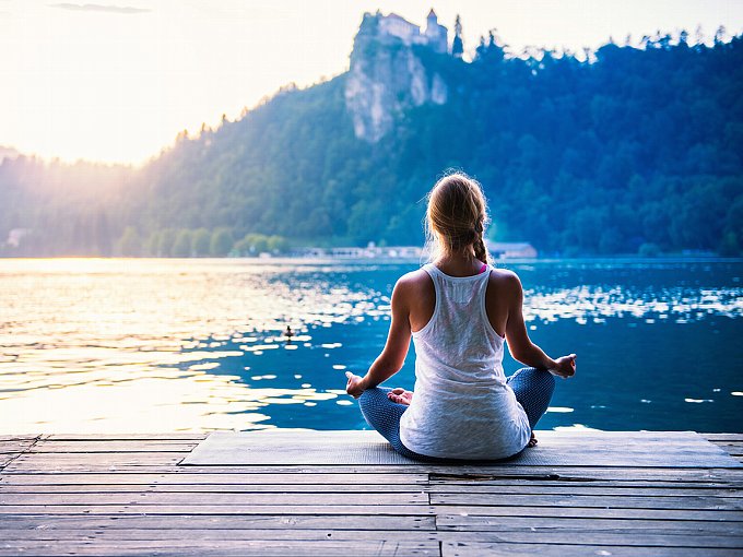 湖のそばで瞑想をする女性