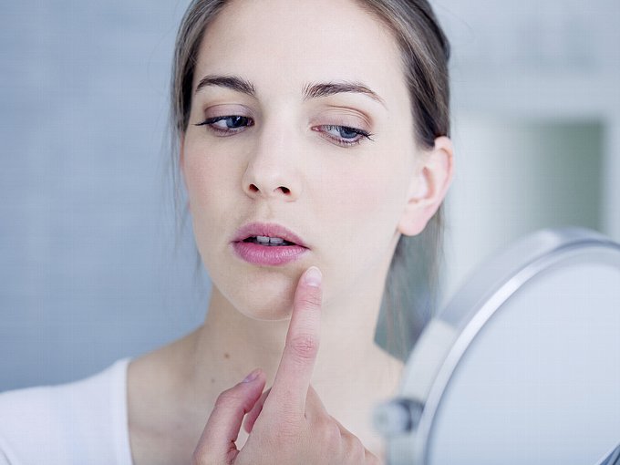 鏡で自分の顔をチェックする女性