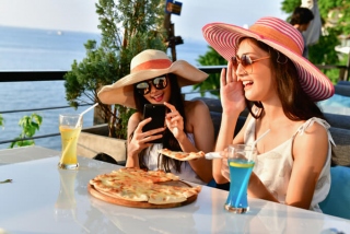 テラスでピザを食べている女性２人