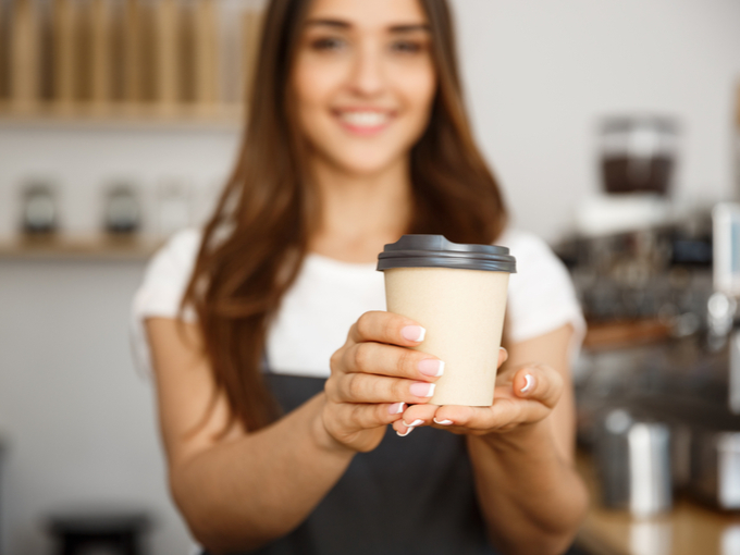 女性がコーヒーを手渡している画像