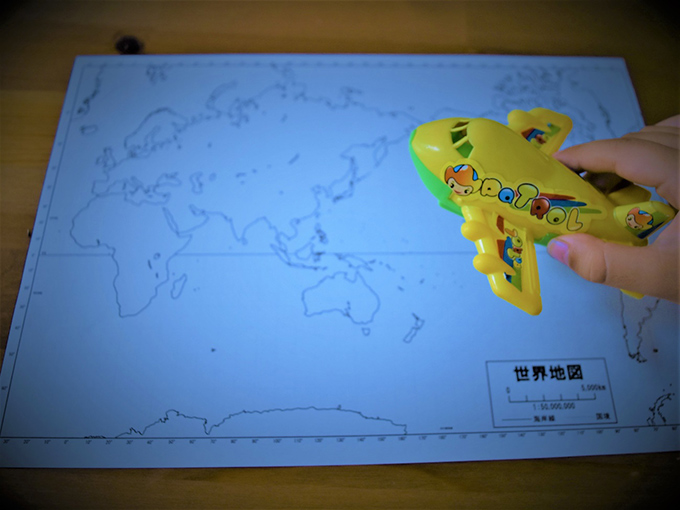 世界地図とおもちゃの飛行機の画像