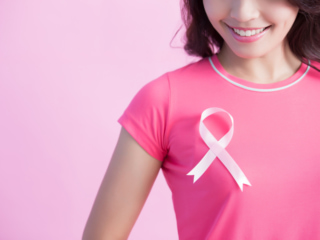 乳がん検診の啓発活動の印「ピンクリボン」をつけた人