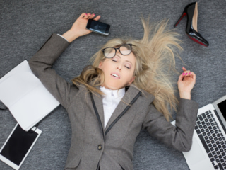オフィスの床に寝ている疲労困憊の女性
