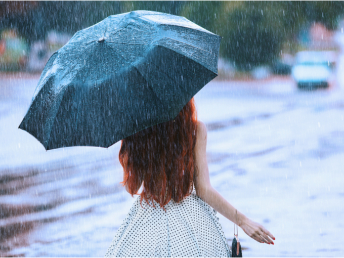 雨の中傘をさす女性のうしろ姿