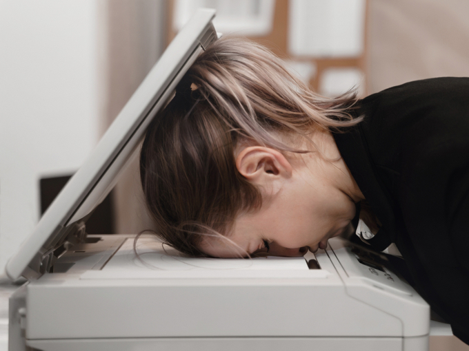 コピー機に顔をつけて寝る女性