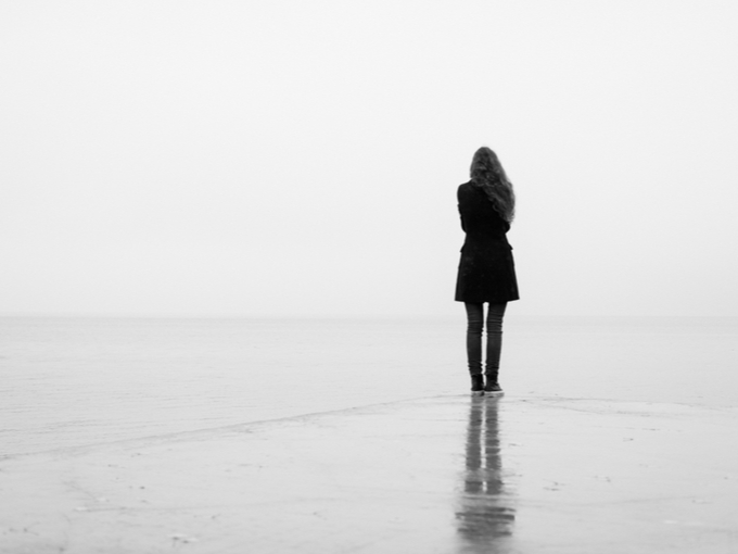ひとりで海岸に立たずむ女性