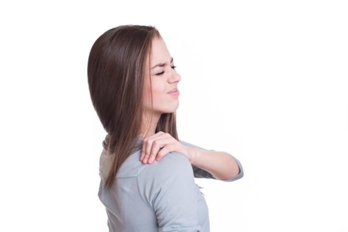 肩を痛そうに触る女性の画像