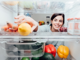 冷蔵庫から食べものをとっている女性
