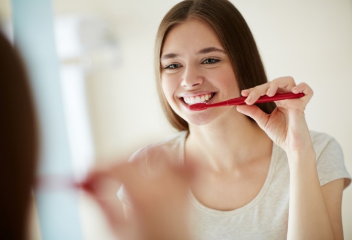 歯ブラシを歯に当てる女性画像
