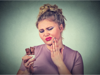 チョコレートを食べながら虫歯を気にする女性
