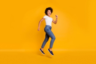 オレンジの背景で跳んでいる女性の画像