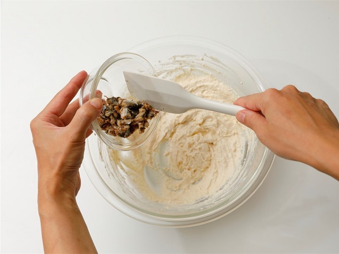 （３）豆腐を加えて泡立て器でなめらかになるまで混ぜ、オイルサーディンを加えてゴムベラで混ぜる。