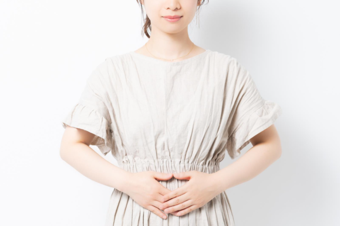お腹に手を当てている女性