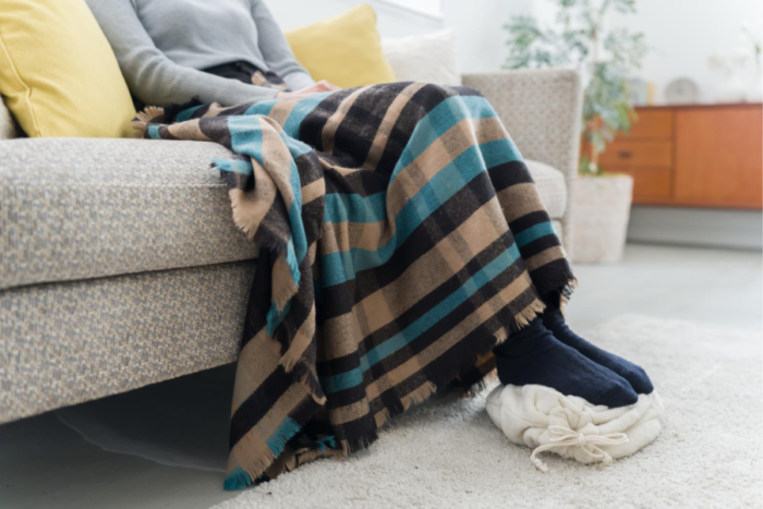 湯たんぽで足元を温める女性