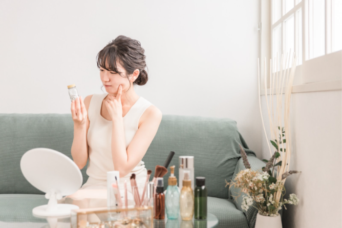 考えながら瓶を眺めている女性