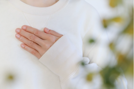 胸に手を当てる女性のイメージ画像