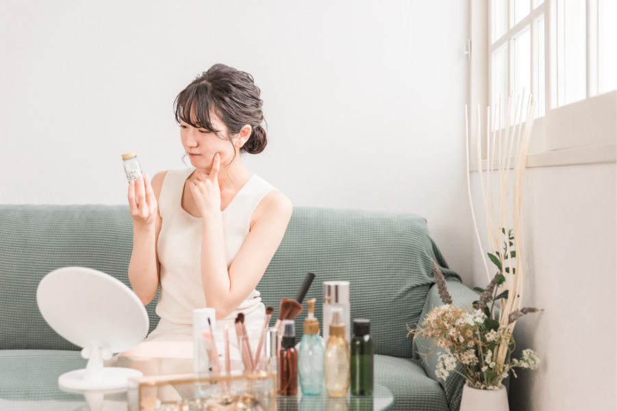 薬の瓶を持ち、考えている女性