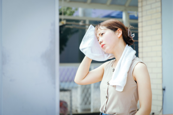 暑さでタオルを首にかける女性