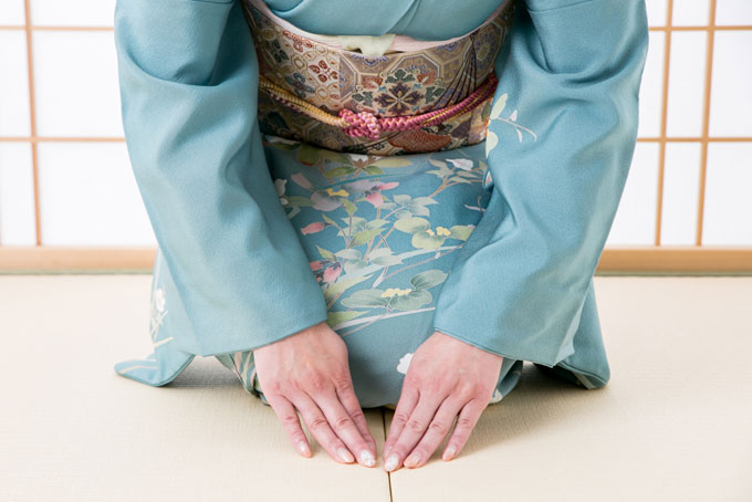 着物を着た女性が畳の上で手をそろえている手元