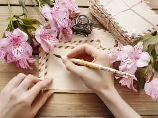 ペンで文字を書こうとしている女性の手元