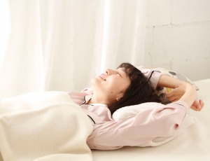 ピンクのパジャマと白い毛布