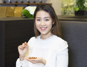 アーモンドを手に持つミュリエル・キムさん
