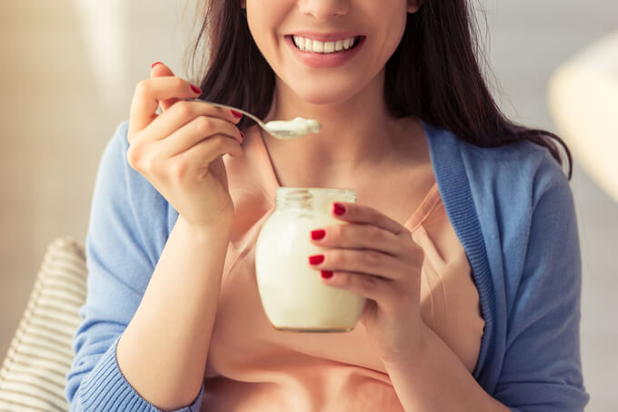ヨーグルトを食べている女性の画像