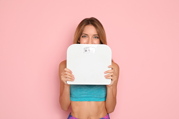体重計を持っている女性の画像