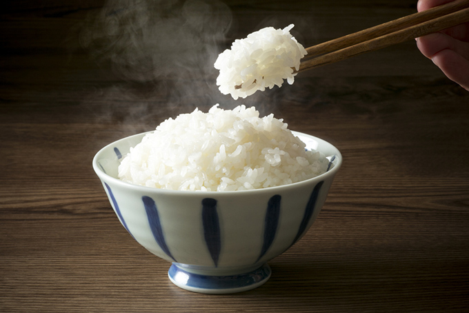 炊きたての白米を箸で食べようとしているイメージ画像