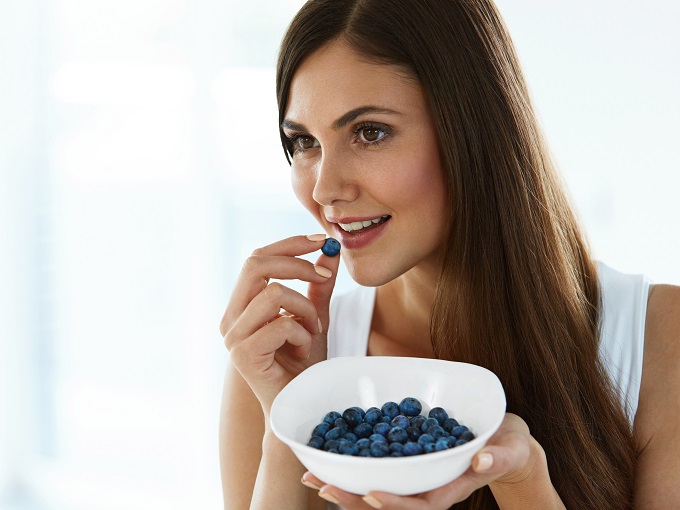 シャッターストック_ブルーベリーを食べている女性の画像