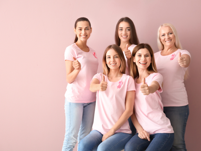 ピンクのTシャツにピンクリボンのバッチをつけた女性たち