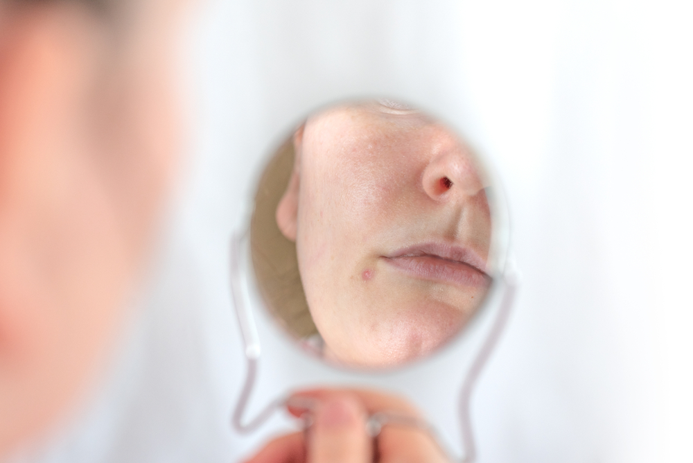 手鏡で自分の顔を写しているイメージ画像