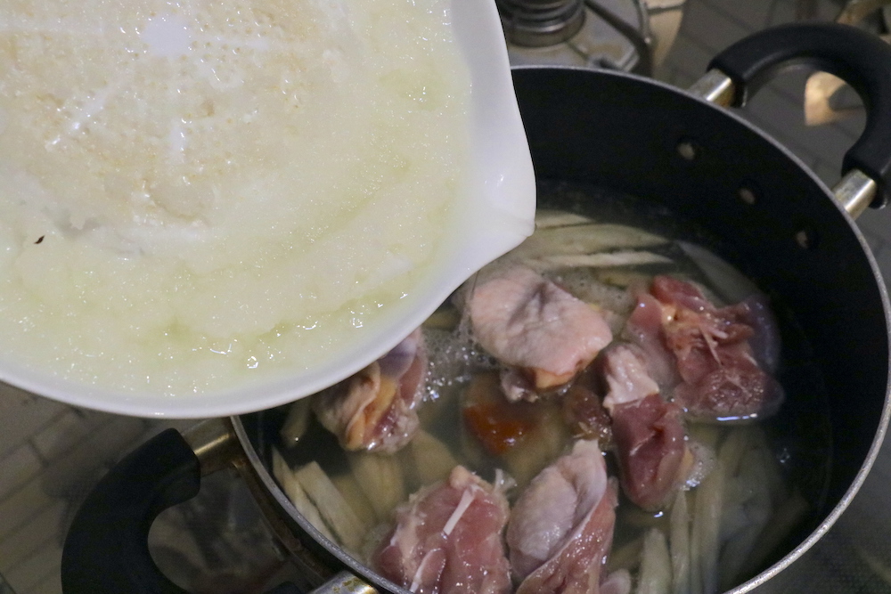 煮込んだごぼうに鶏肉大根おろし、しょうゆを入れて再度煮込む