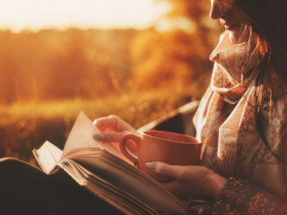 秋の公園で読書する女性