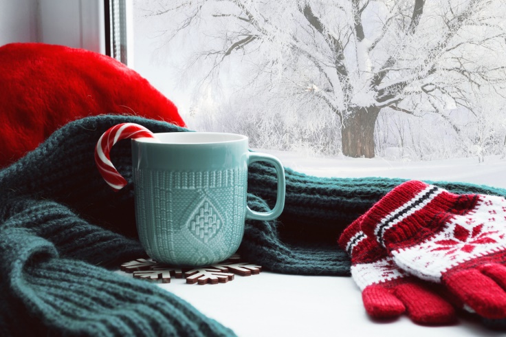 冬の窓辺に手袋とカップ、マフラーなど